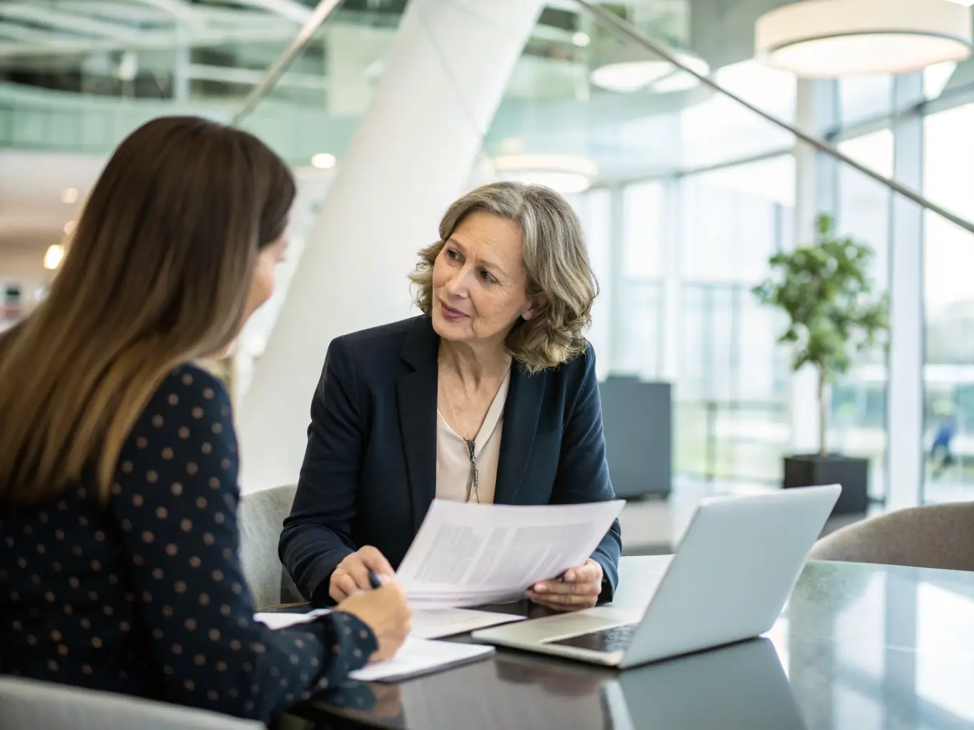 A financial consultant in a modern office setting, reviewing investment portfolios with a client, showcasing personalized financial planning.